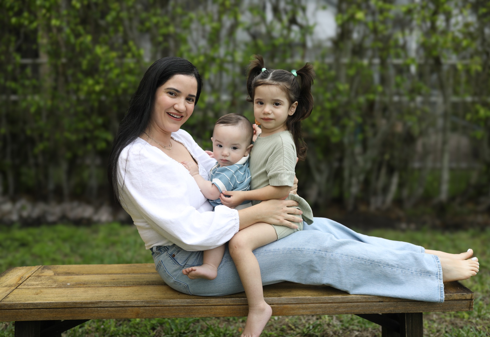 Mother sitting outdoors with two children